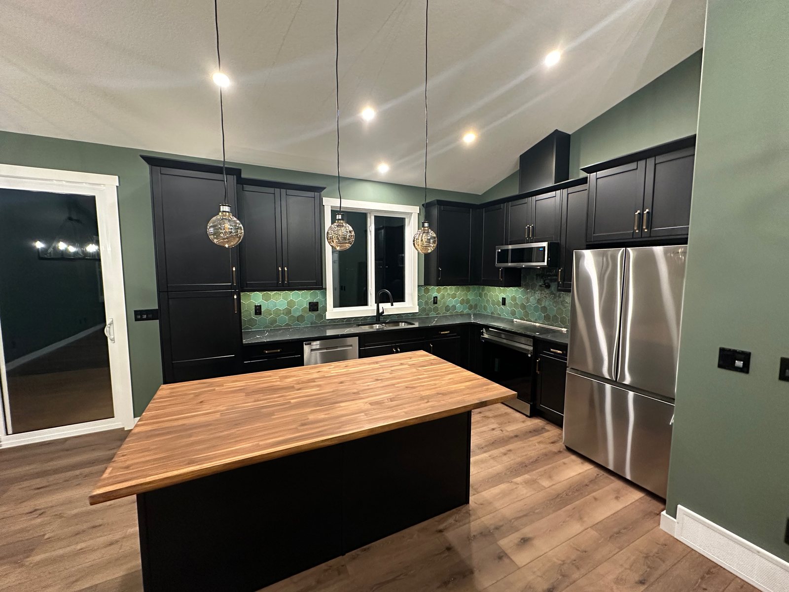 Kitchen with a dark island and light cabinetry